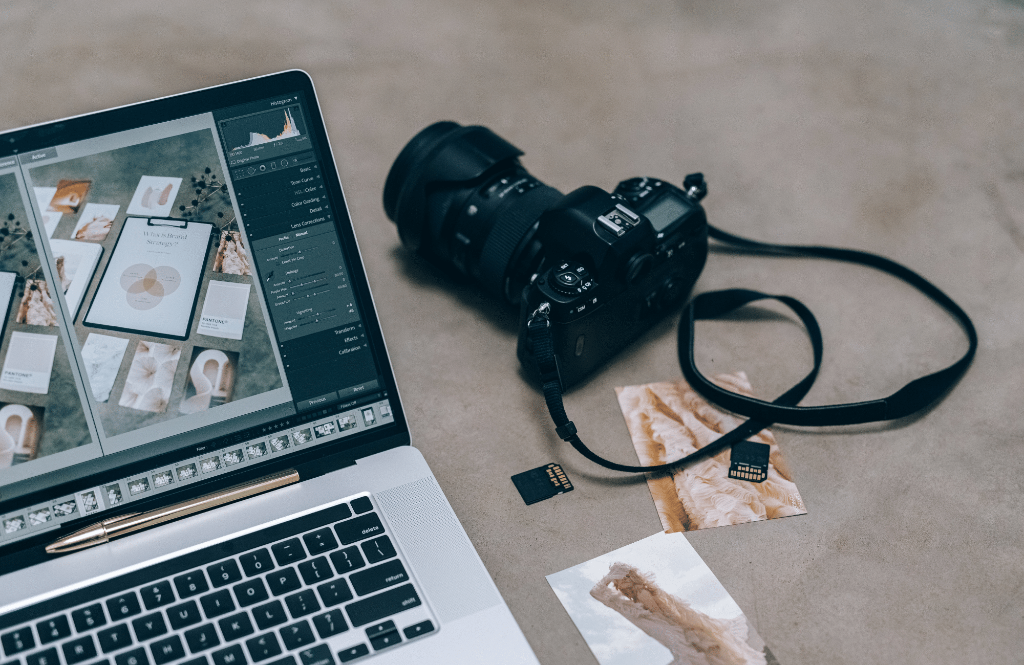 A camera and its memory card sitting next to a computer.