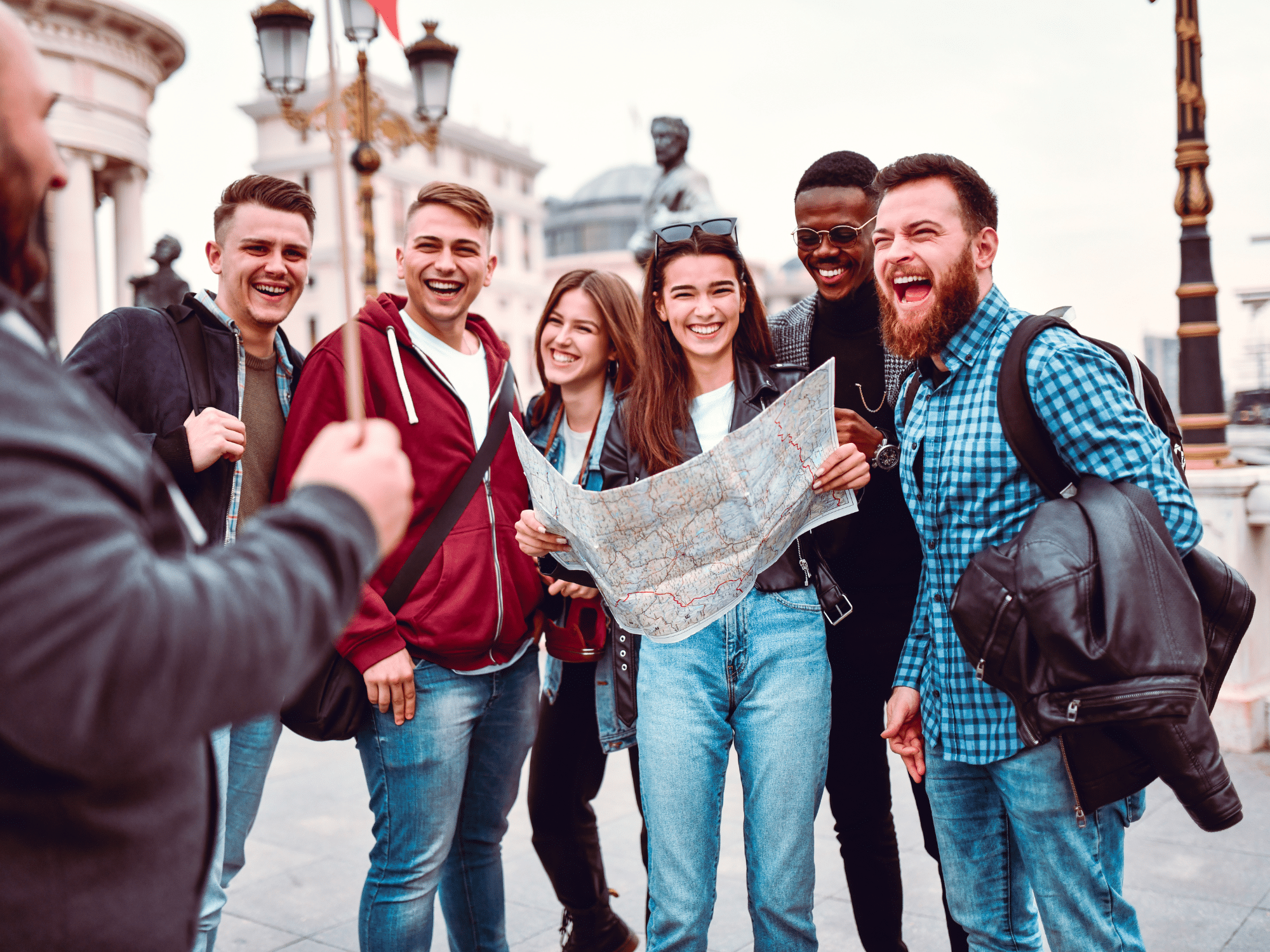 People laughing holding a map in a foreign city.