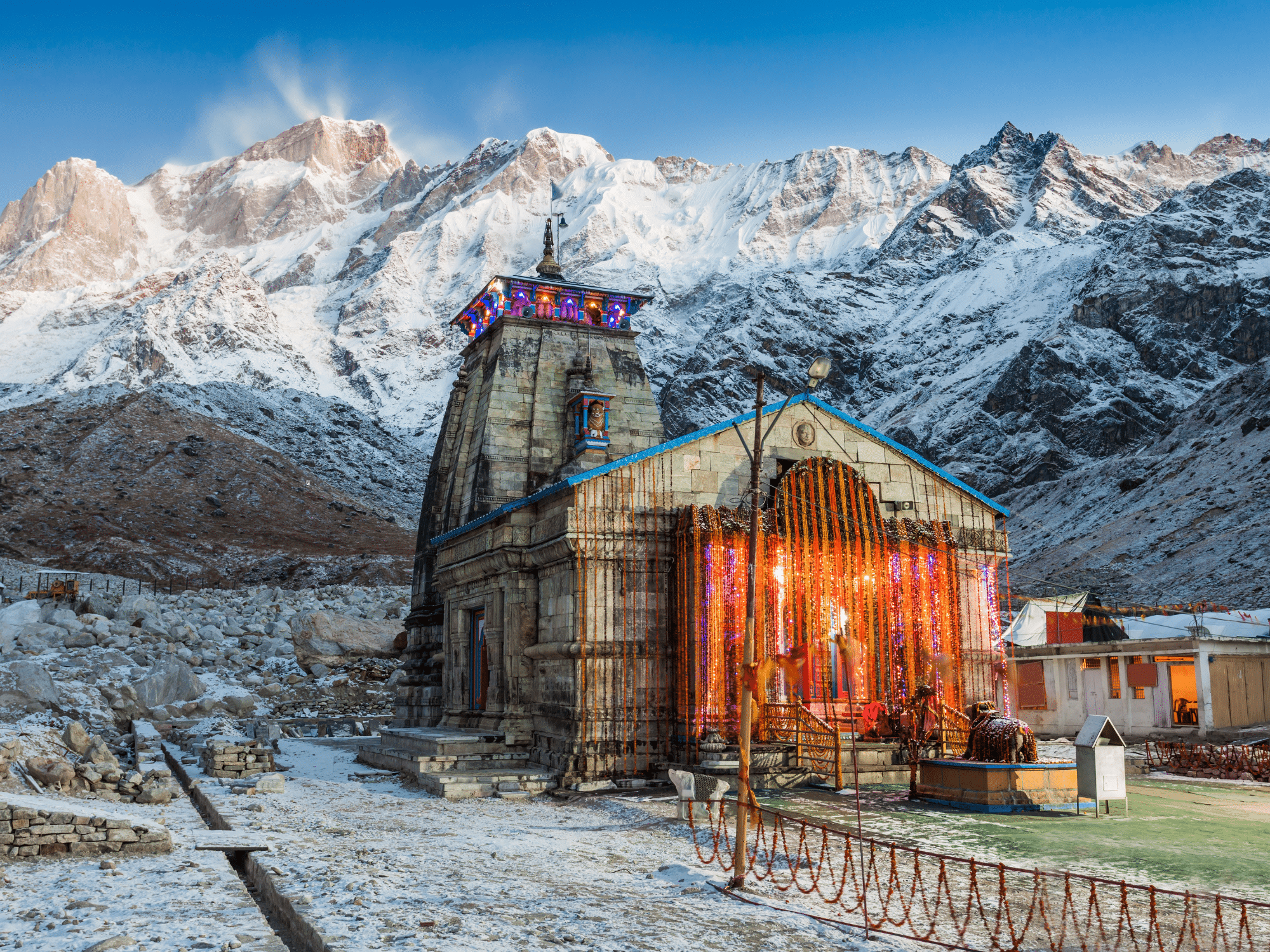 A temple against a snowy mountain backdrop.