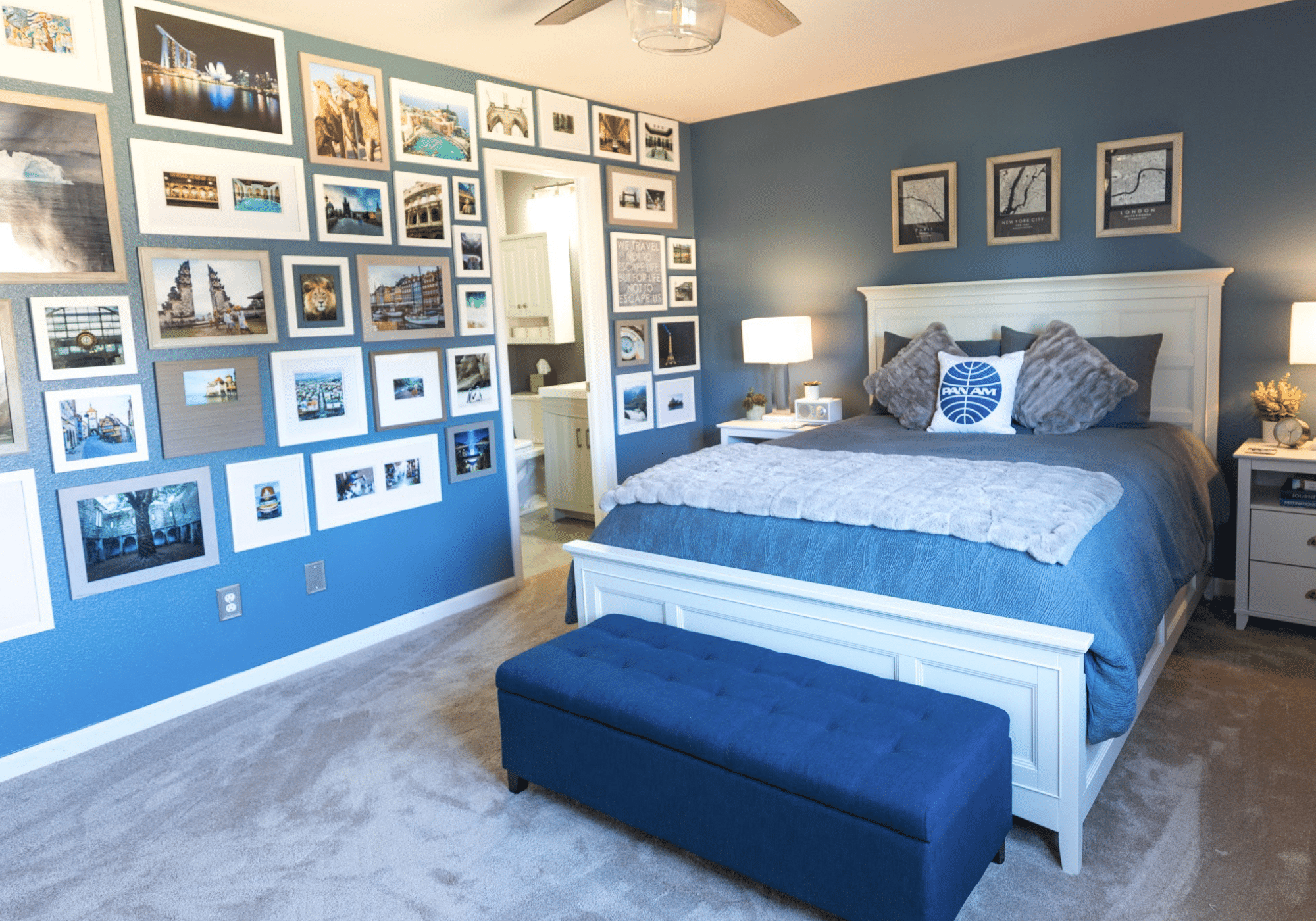 A blue bedroom with a wall of framed photos.
