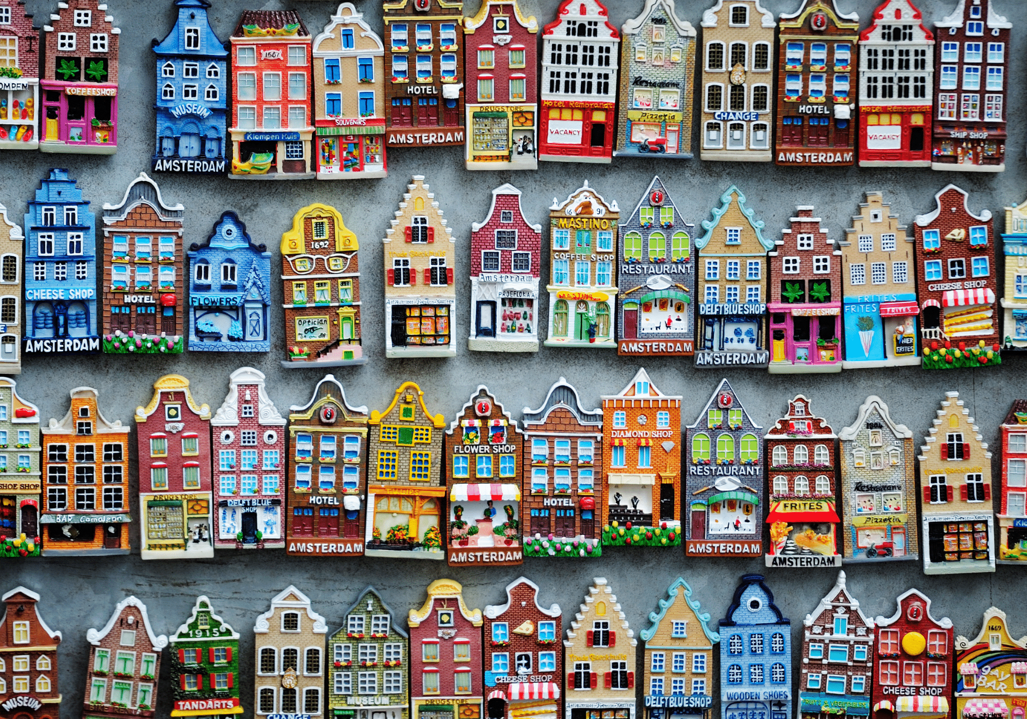 A wall full of travel magnets in the shapes of homes in Amsterdam.