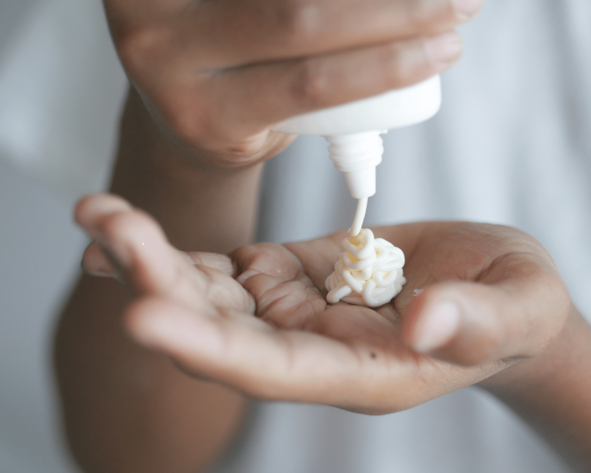 Pouring lotion into a hand.