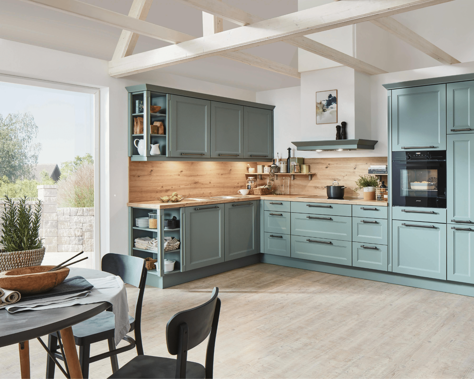 A beautiful home kitchen with teal cabinets and a kitchen table.