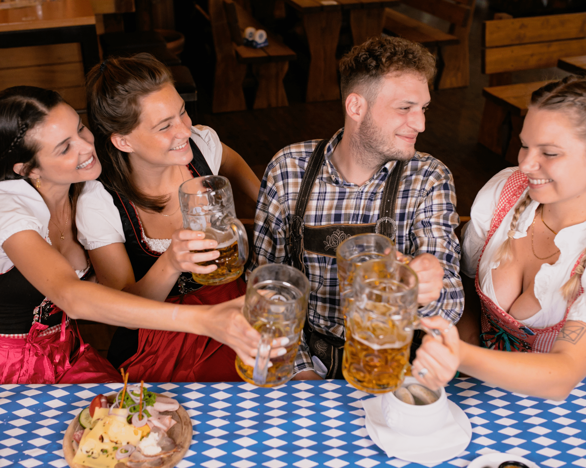 Four young people drinking beer at Oktoberfest.